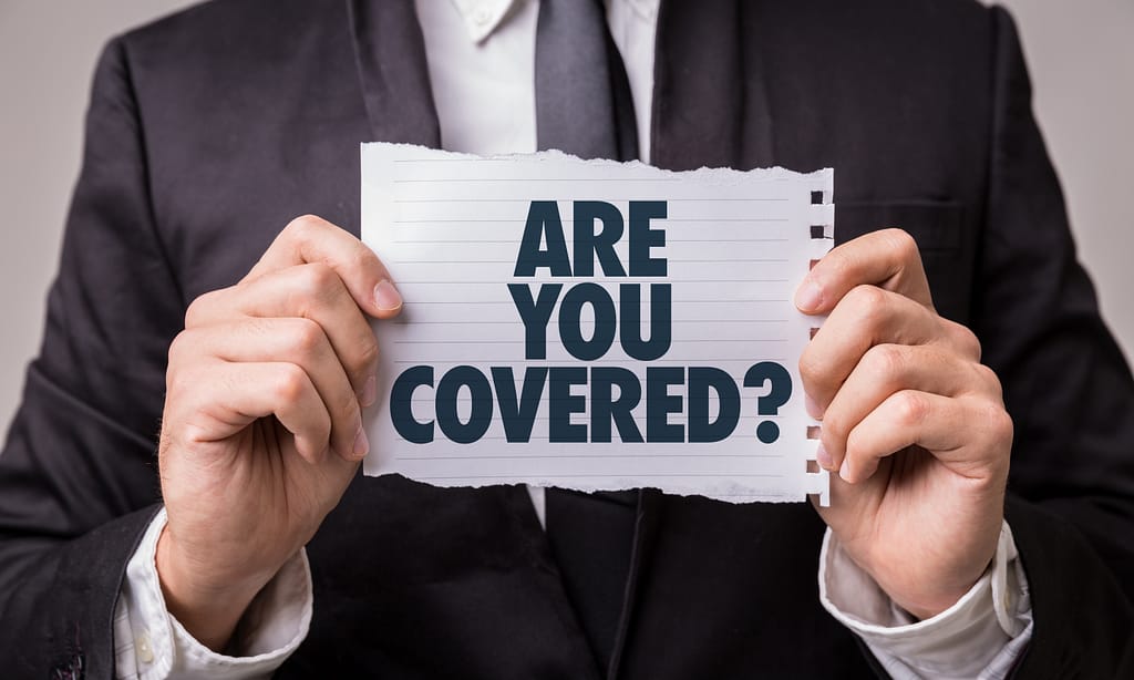 Image of man holding "are you covered"