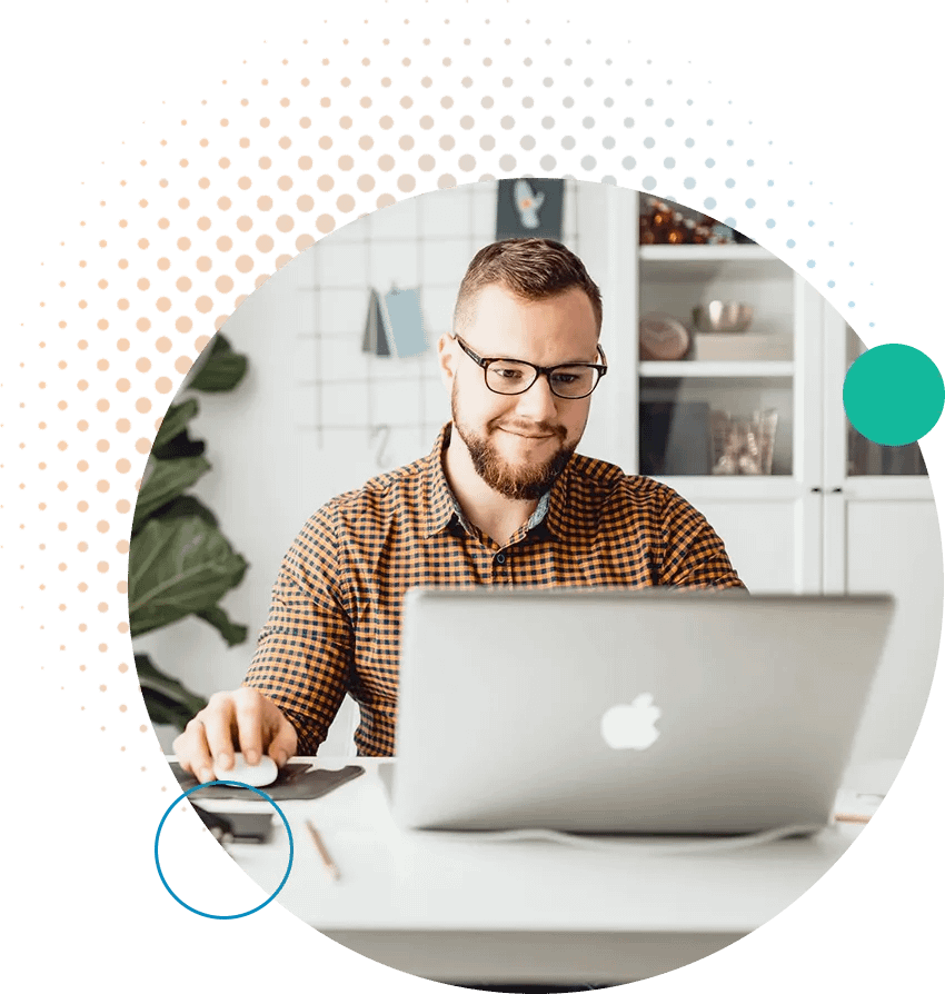 Man intently looking at a laptop screen while holding a mouse, indicating focused work or study.